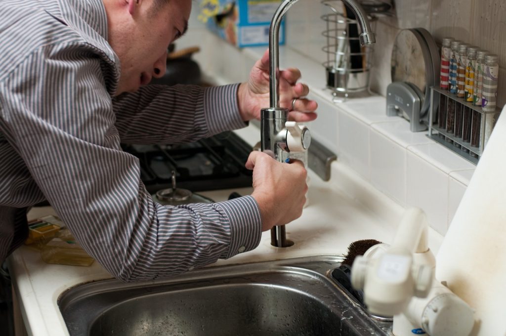 A plumber fixing one of the most common plumbing issues for California homeowners, leaky taps.