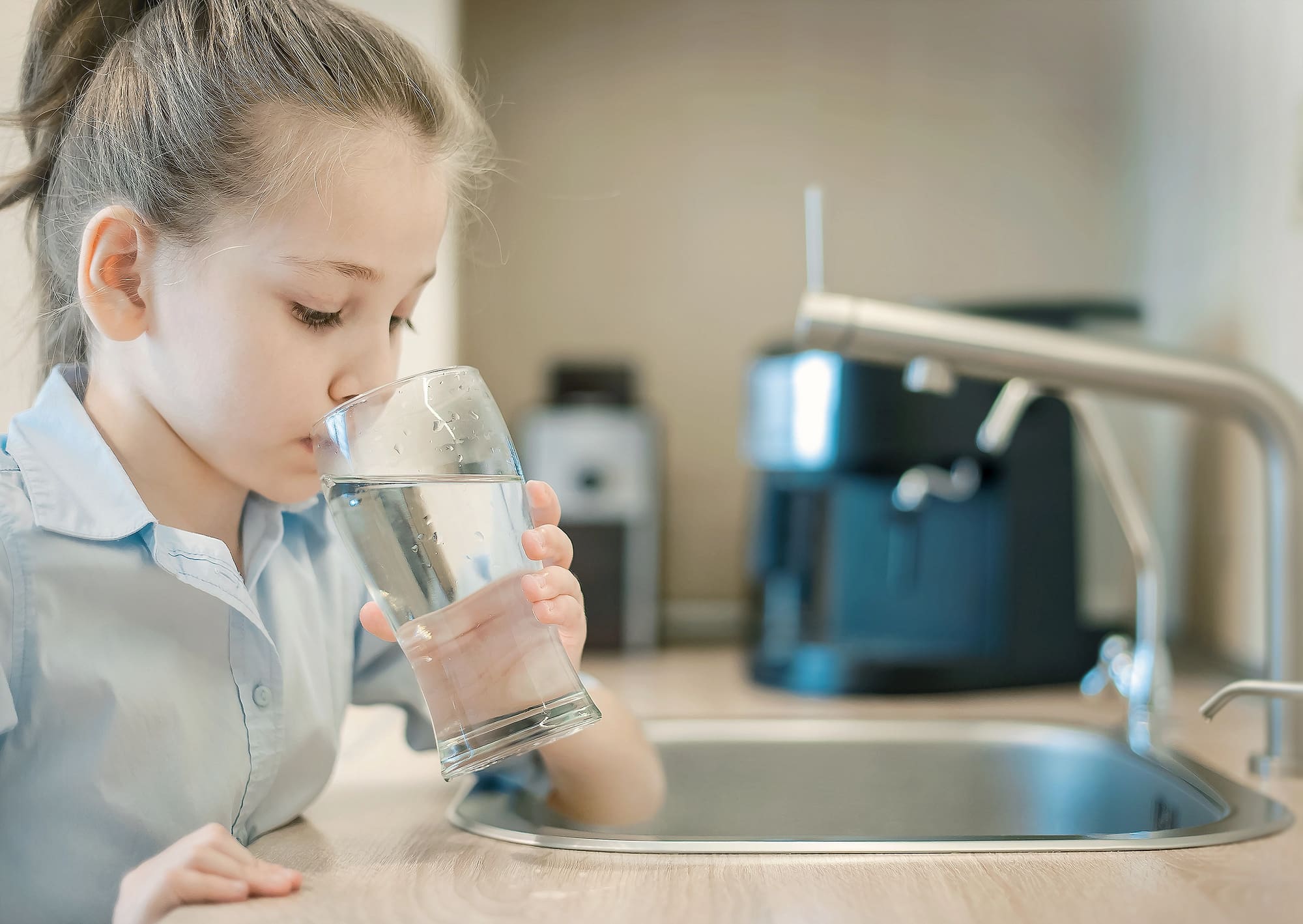 Young girl drinking clean water, protected by backflow testing San Francisco services for safe consumption