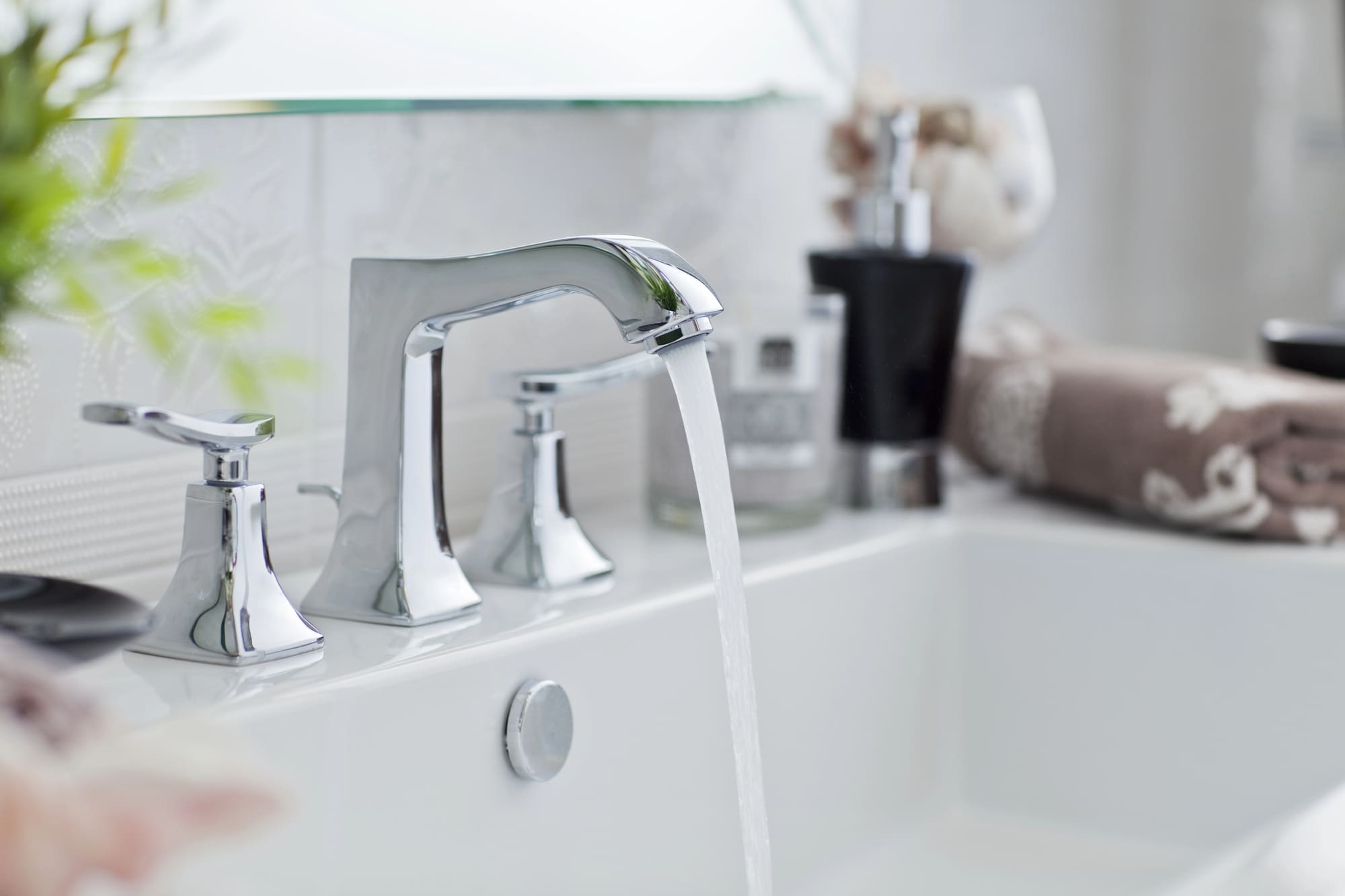 24-hour plumber San Francisco: Modern chrome bathroom faucet installation with running water