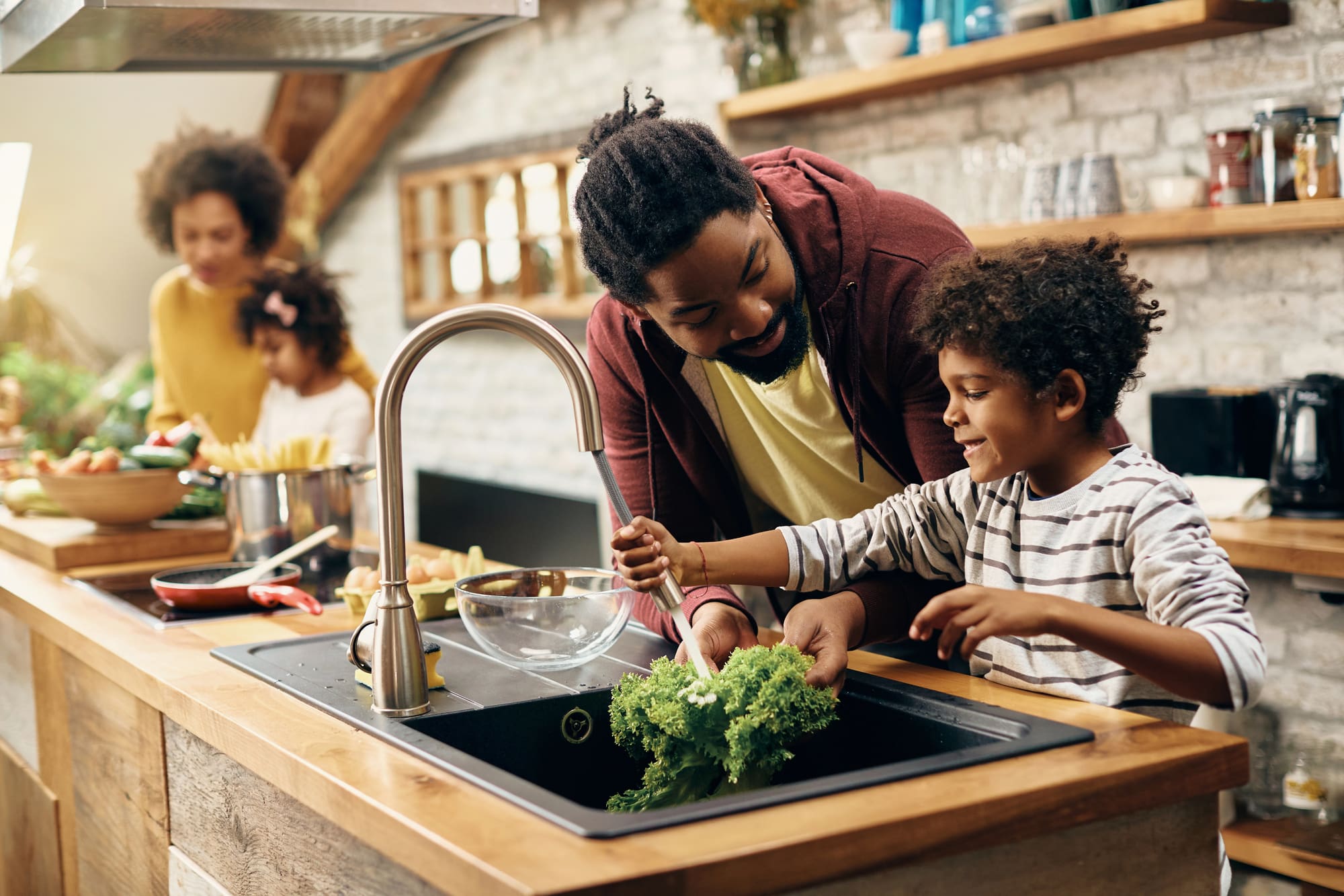 Faucet installation San Francisco kitchen with father and son washing vegetables