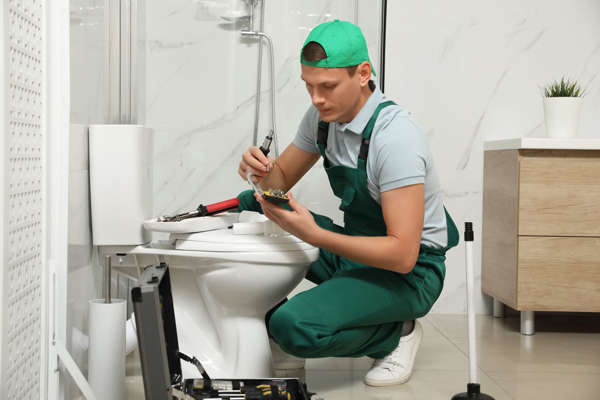 Toilet installation San Francisco plumber carefully working in modern bathroom