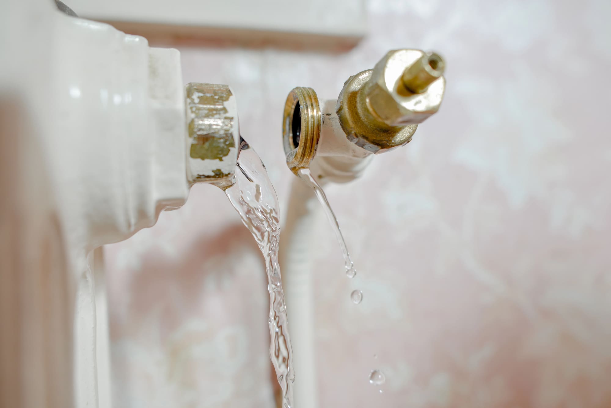 Emergency water heater repair San Francisco: showing leaking brass valve with water streaming down
